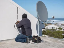 A technician on a roof completing an installation in Murdock Valley